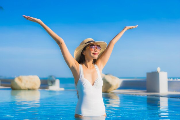 Portrait beautiful young asian woman happy smile relax around outdoor swimming pool in hotel resort