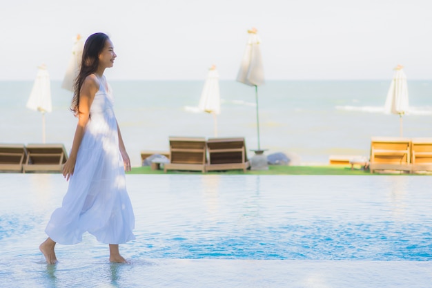 Free Photo portrait beautiful young asian woman happy smile and relax around swimming pool in hotel resort