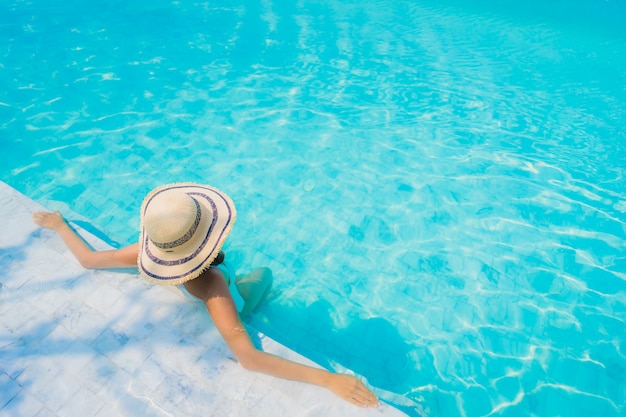 Portrait beautiful young asian woman happy smile relax in swimming pool for travel vacation