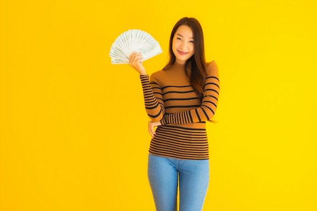 Free photo portrait beautiful young asian woman happy smile and rich with a lot of cash in her hand