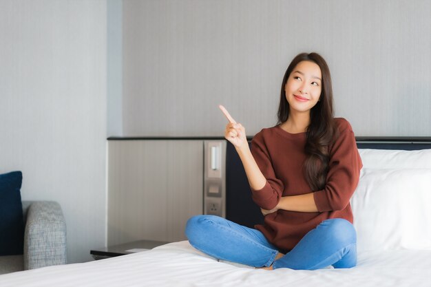 Portrait beautiful young asian woman relax on bed in bedroom interior