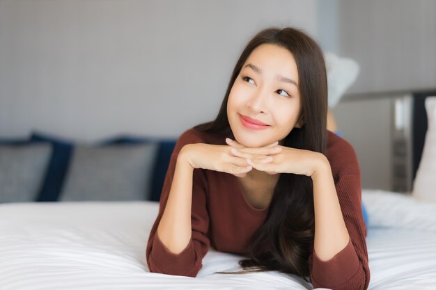 Portrait beautiful young asian woman relax on bed in bedroom interior