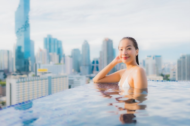 Portrait beautiful young asian woman relax happy smile leisure around outdoor swimming pool