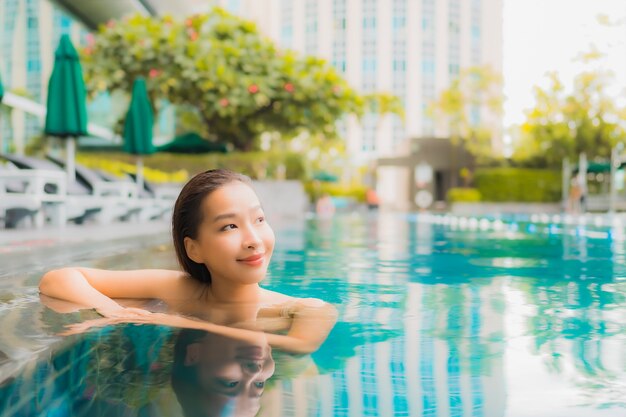 Portrait beautiful young asian woman relax happy smile leisure around outdoor swimming pool