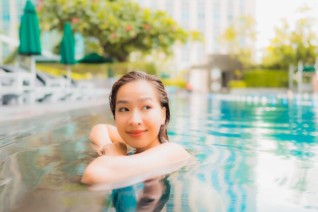 Portrait beautiful young asian woman relax happy smile leisure around outdoor swimming pool