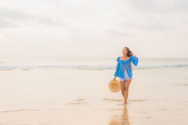 Portrait beautiful young asian woman relax leisure smile around beach sea ocean at sunset time