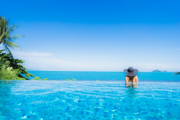 Portrait beautiful young asian woman relax in luxury outdoor swimming pool in hotel resort nearly beach sea ocean