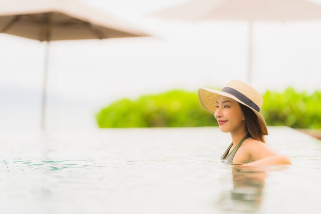 Portrait beautiful young asian woman relax in luxury outdoor swimming pool in hotel resort nearly beach sea ocean