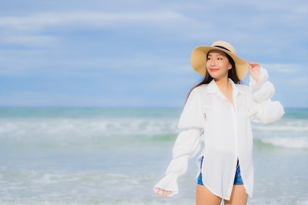 Portrait beautiful young asian woman relax smile around beach sea ocean in holiday vacation travel trip