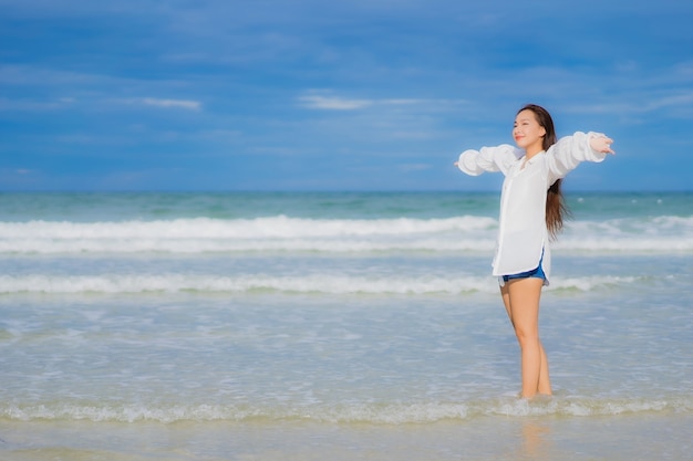 Portrait beautiful young asian woman relax smile around beach sea ocean in holiday vacation travel trip