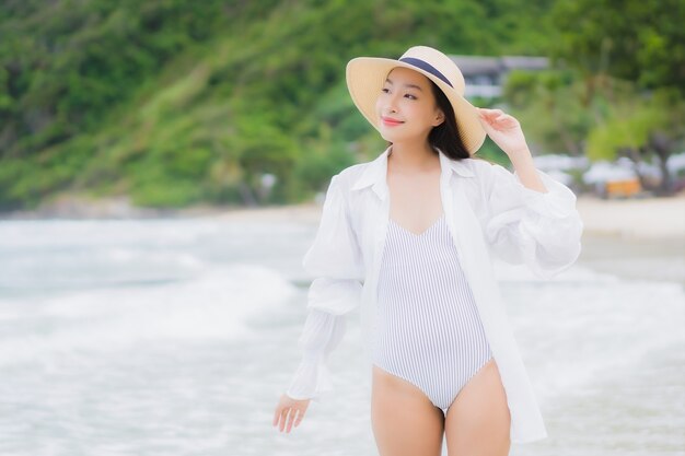 Portrait beautiful young asian woman relax smile around beach sea ocean in holiday vacation travel trip