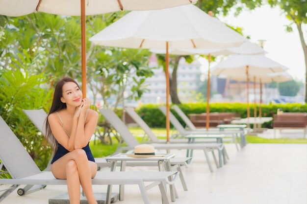 Portrait beautiful young asian woman relax smile around outdoor swimming pool in hotel resort in vacation travel