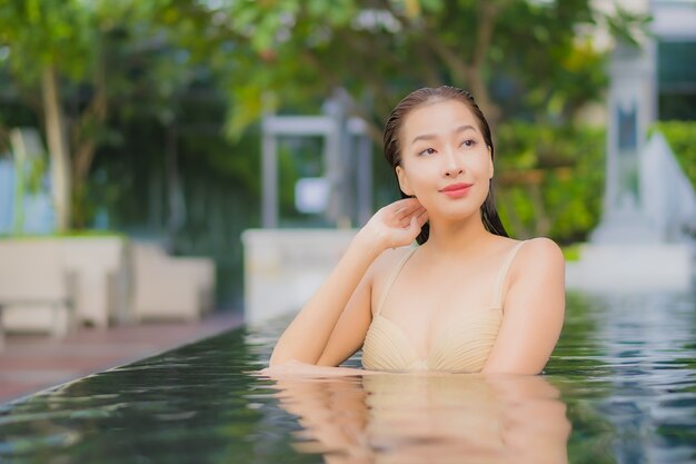 Portrait beautiful young asian woman relax smile around outdoor swimming pool in hotel resort on vacation travel