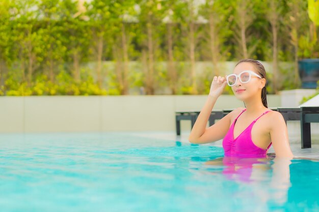 Portrait beautiful young asian woman relax smile around outdoor swimming pool in hotel resort 