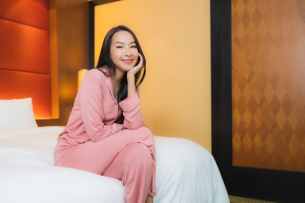 Portrait beautiful young asian woman relax smile happy on bed in bedroom interior