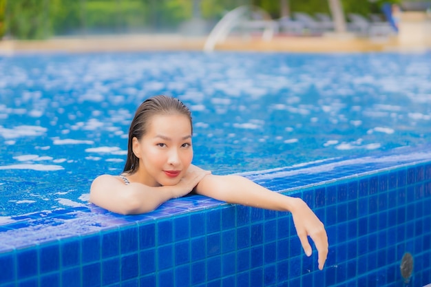 Portrait beautiful young asian woman relax smile leisure around outdoor swimming pool in hotel resort on vacation travel