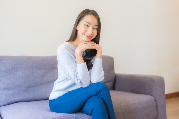 Portrait beautiful young asian woman relax smile on sofa in living room