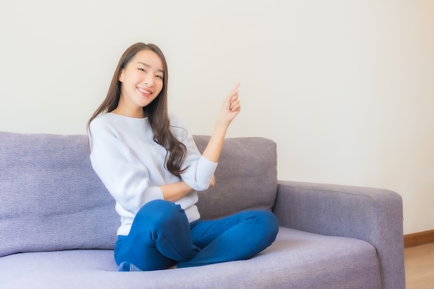 Portrait beautiful young asian woman relax smile on sofa in living room