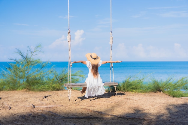 Portrait beautiful young asian woman relax smile on swing around beach sea ocean for nature travel in vacation