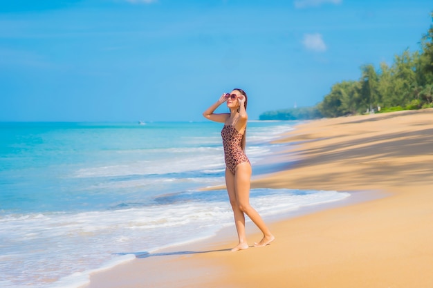 Portrait of beautiful young asian woman relaxing around beach with white clouds on blue sky in travel vacation