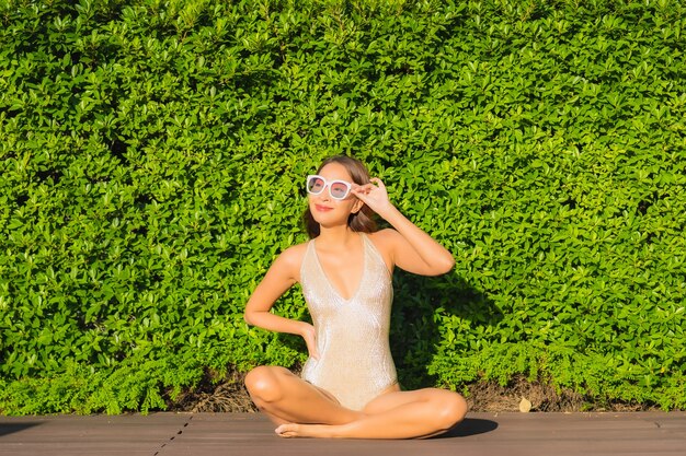 Portrait of beautiful young asian woman relaxing around outdoor swimming pool in hotel resort