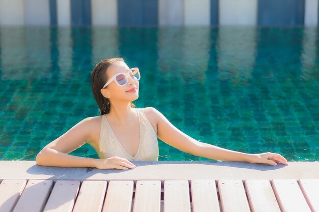 Portrait of beautiful young asian woman relaxing around outdoor swimming pool in hotel resort