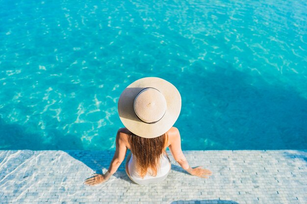 Portrait beautiful young asian woman relaxing around outdoor swimming pool with city view