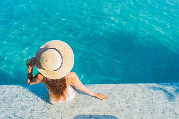 Portrait beautiful young asian woman relaxing around outdoor swimming pool with city view