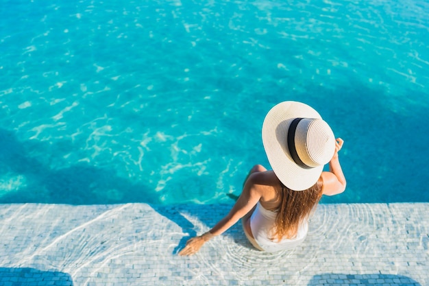 Portrait beautiful young asian woman relaxing around outdoor swimming pool with city view