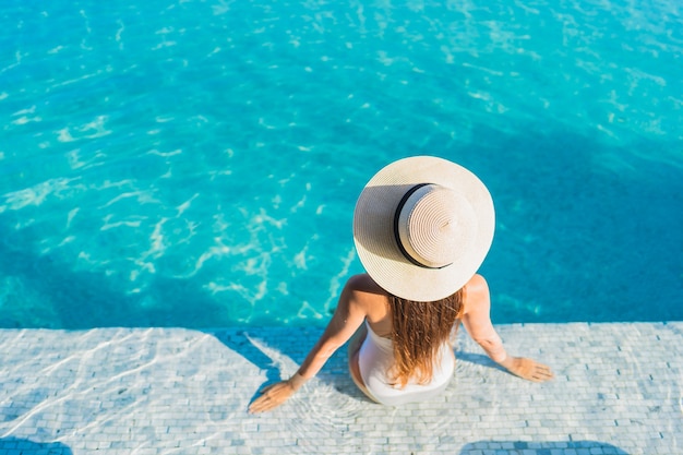 Portrait beautiful young asian woman relaxing around outdoor swimming pool with city view