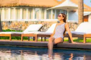 Free photo portrait beautiful young asian woman relaxing around swimming pool in resort hotel on vacation