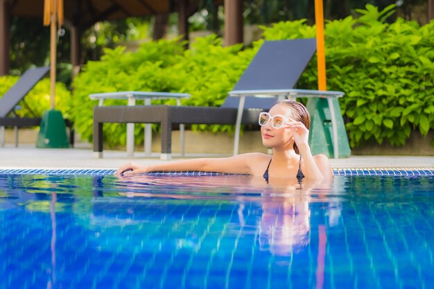 Portrait of beautiful young asian woman relaxinging around outdoor swimming pool in hotel resort