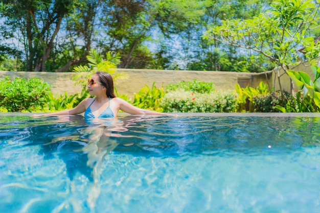 Portrait beautiful young asian woman smile happy relax and leisure in the swimming pool