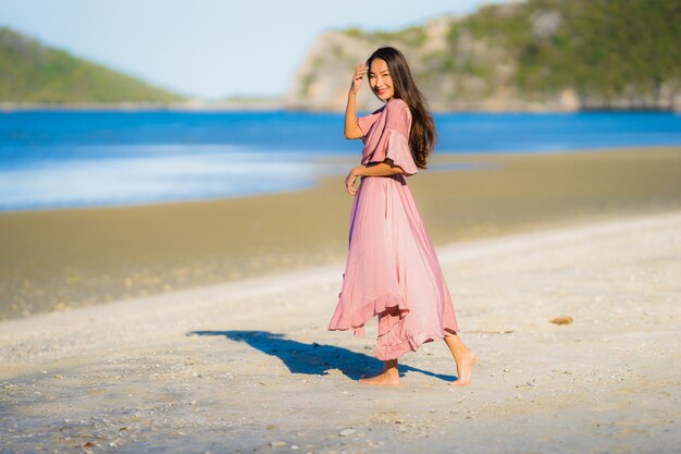 Portrait beautiful young asian woman smile happy walk on the tropical outdoor nature beach sea