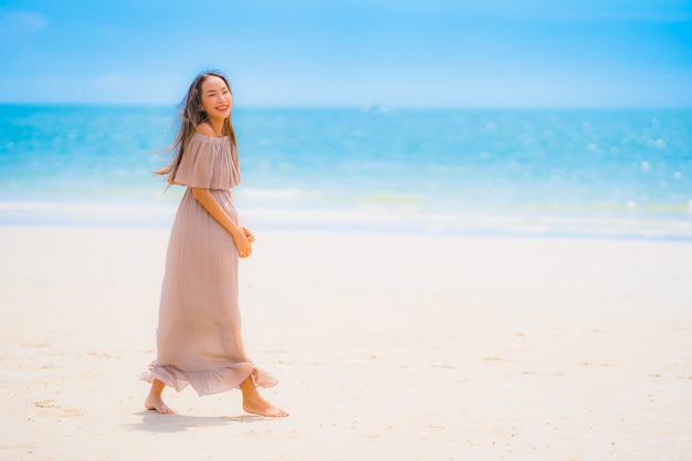 Portrait beautiful young asian woman smile happy walk on the tropical outdoor nature beach sea