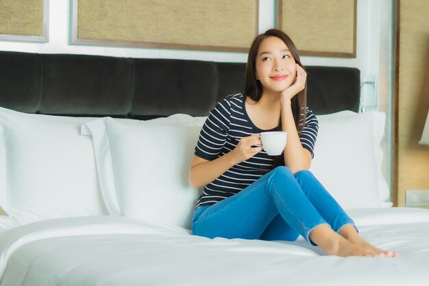 Portrait beautiful young asian woman smile relax on bed in bedroom interior