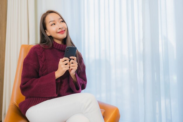 Portrait beautiful young asian woman smile relax on sofa in living room interior