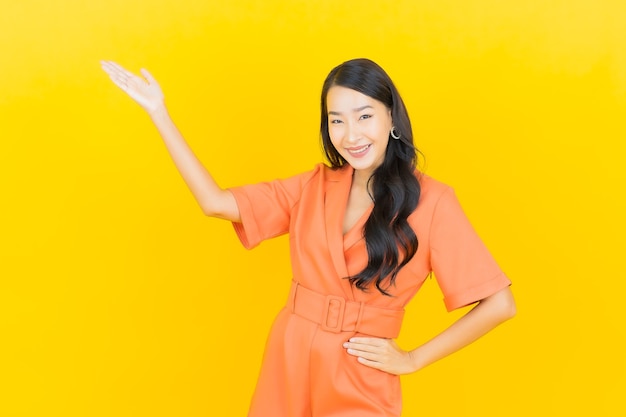 Portrait beautiful young asian woman smile with action on yellow