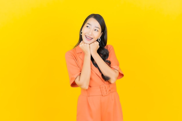 Portrait beautiful young asian woman smile with action on yellow