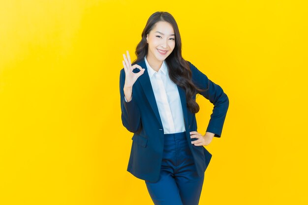 Portrait beautiful young asian woman smile with action on yellow