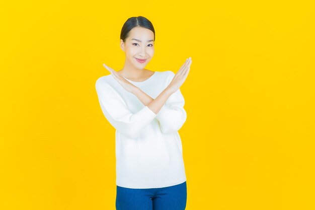 Portrait beautiful young asian woman smile with action on yellow