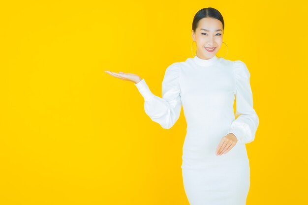 Portrait beautiful young asian woman smile with action on yellow