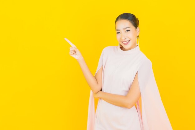 Portrait beautiful young asian woman smile with many action on yellow wall