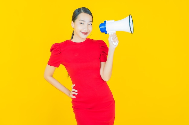 Free Photo portrait beautiful young asian woman smile with megaphone on yellow