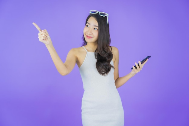 Portrait beautiful young asian woman smile with smart mobile phone on color background