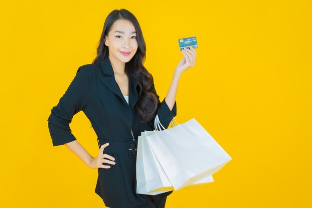 Portrait beautiful young asian woman smile with smart mobile phone on yellow