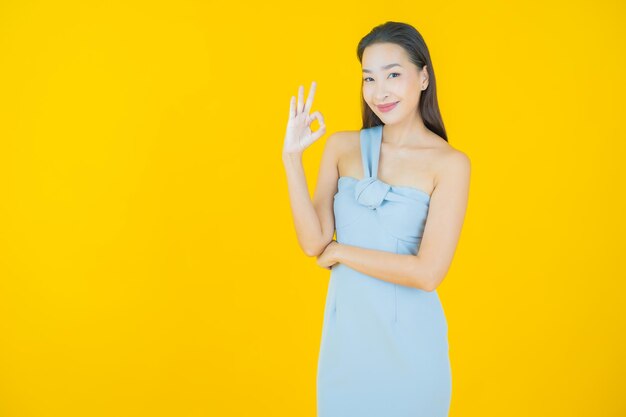 Portrait beautiful young asian woman smile on yellow