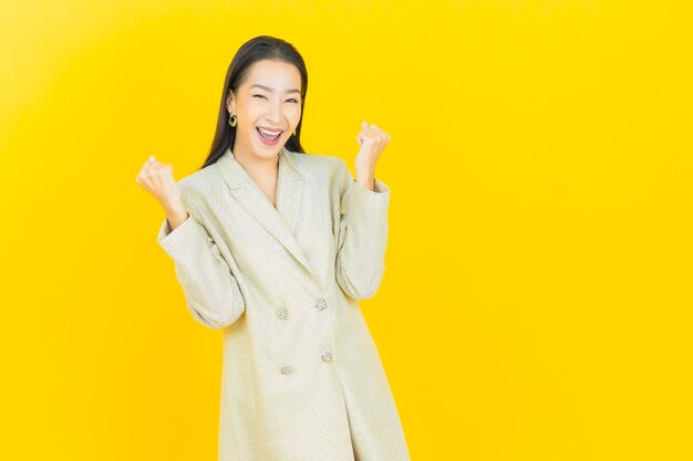 Portrait beautiful young asian woman smiles with action on color wall