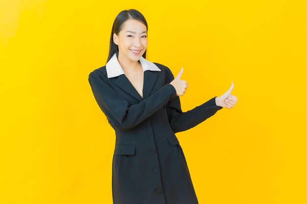 Portrait beautiful young asian woman smiles with action on color wall