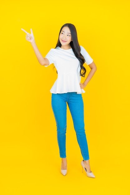 Portrait beautiful young asian woman smiling on yellow